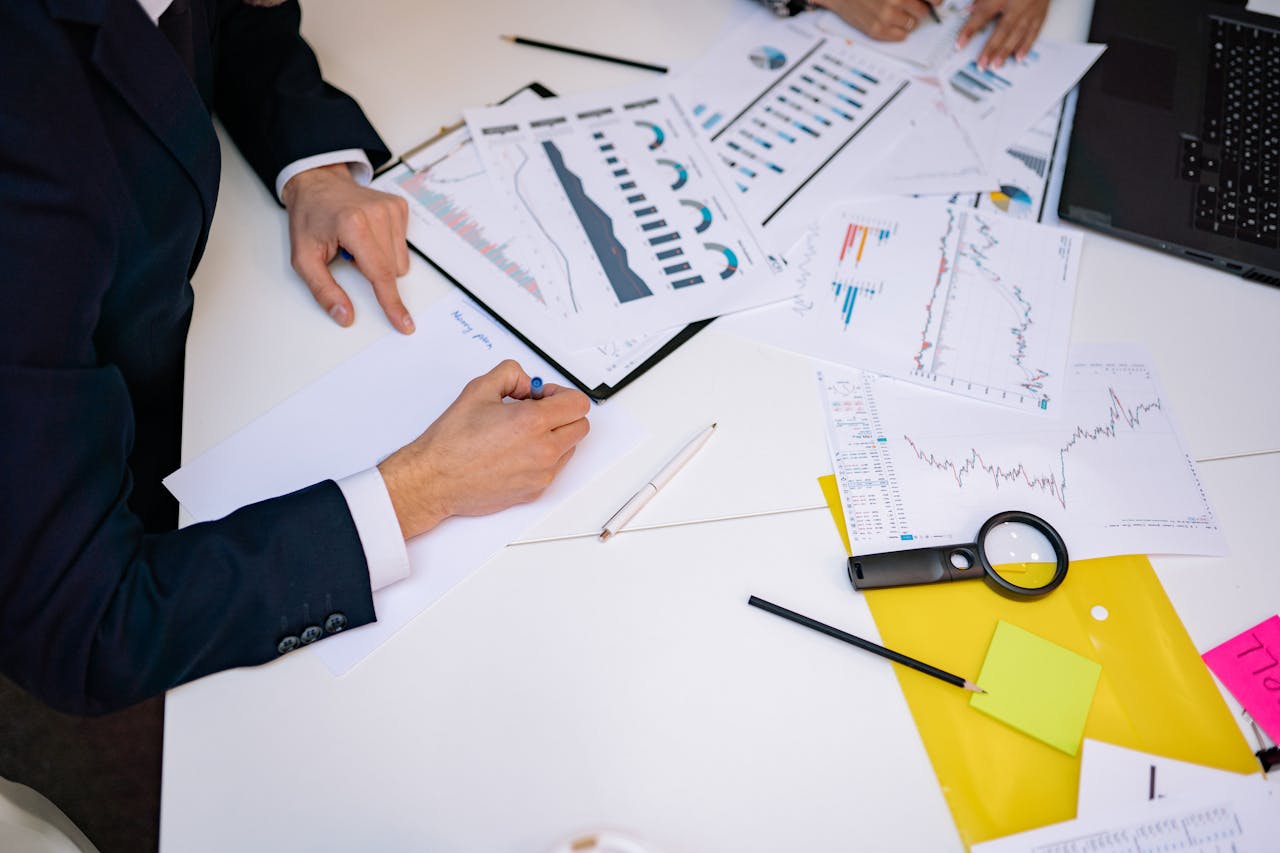 who-we-are Close-up of a desk cluttered with financial charts, graphs, and reports, perfect for business and finance themes.