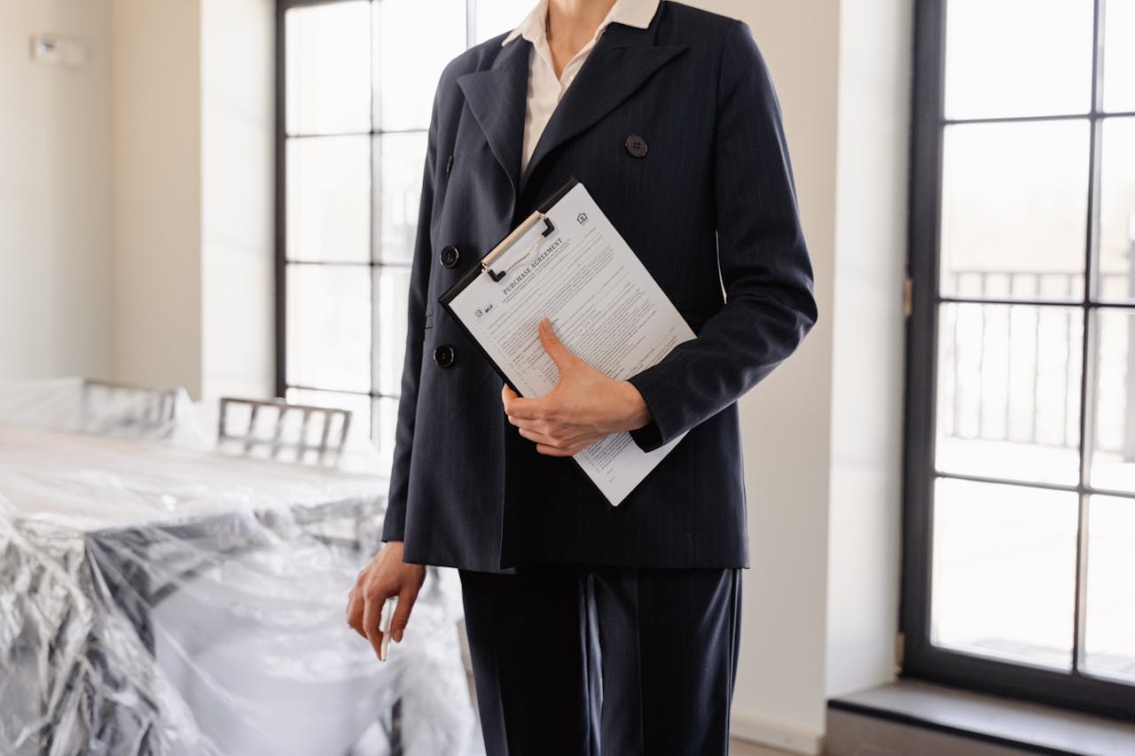 services-03 Professional real estate agent holding documents in a sunlit room, symbolizing success and transactions.